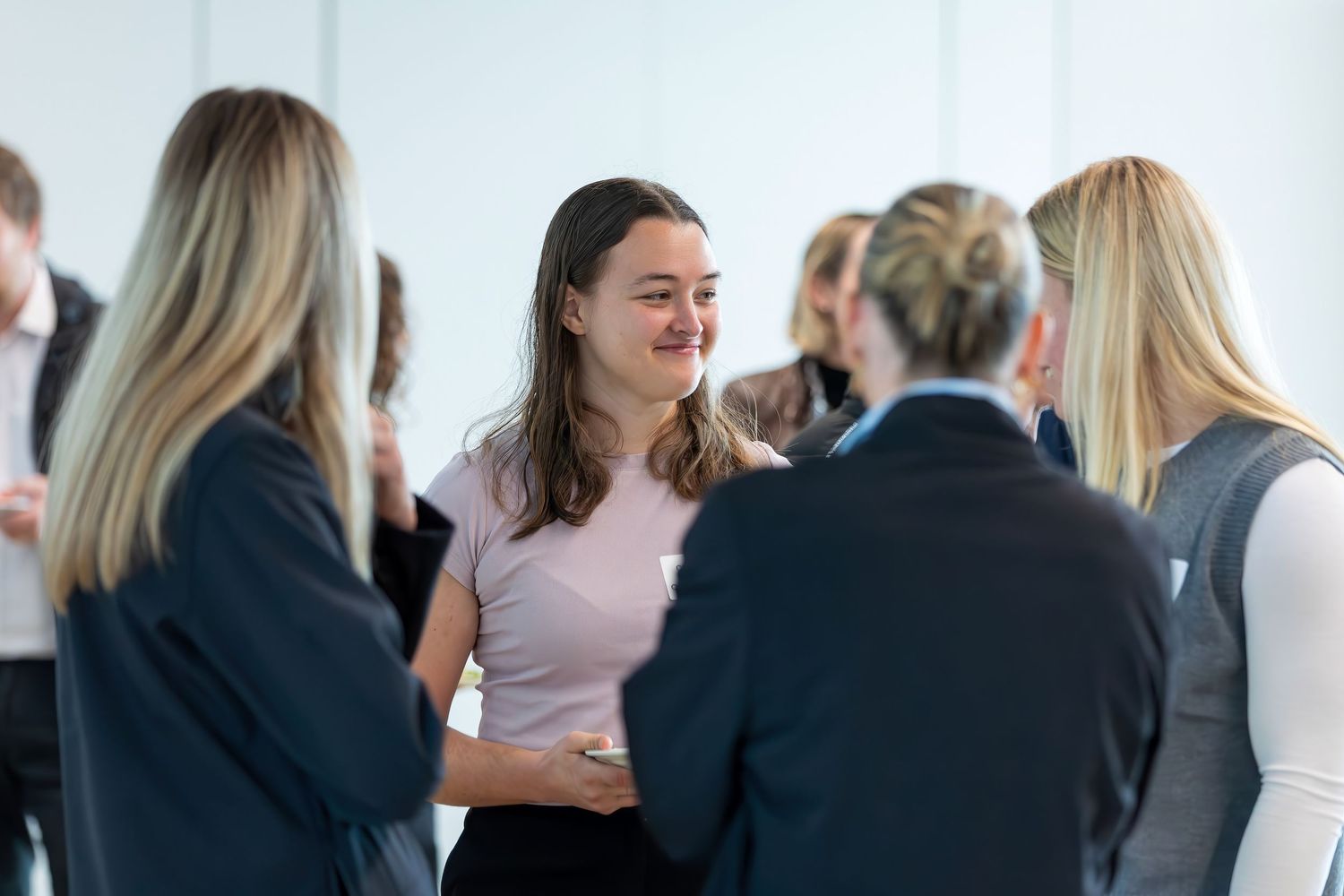 Group of professionals having an animated conversation during a business meeting or networking event.