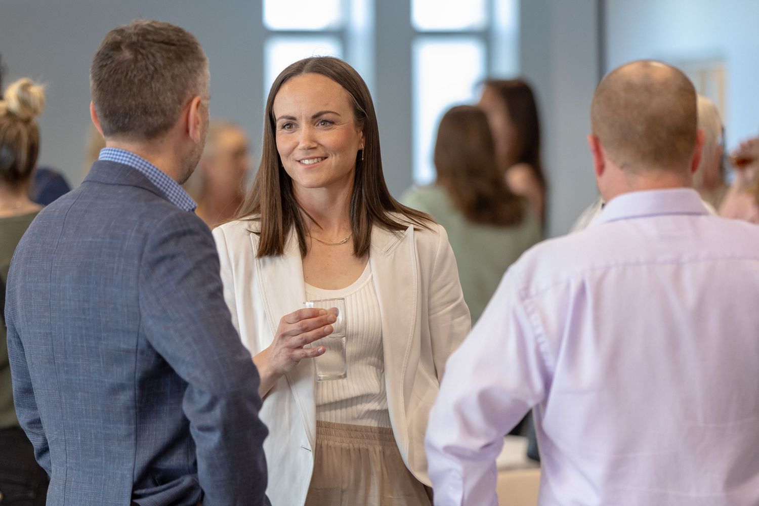 Business networking conversation in modern office environment.