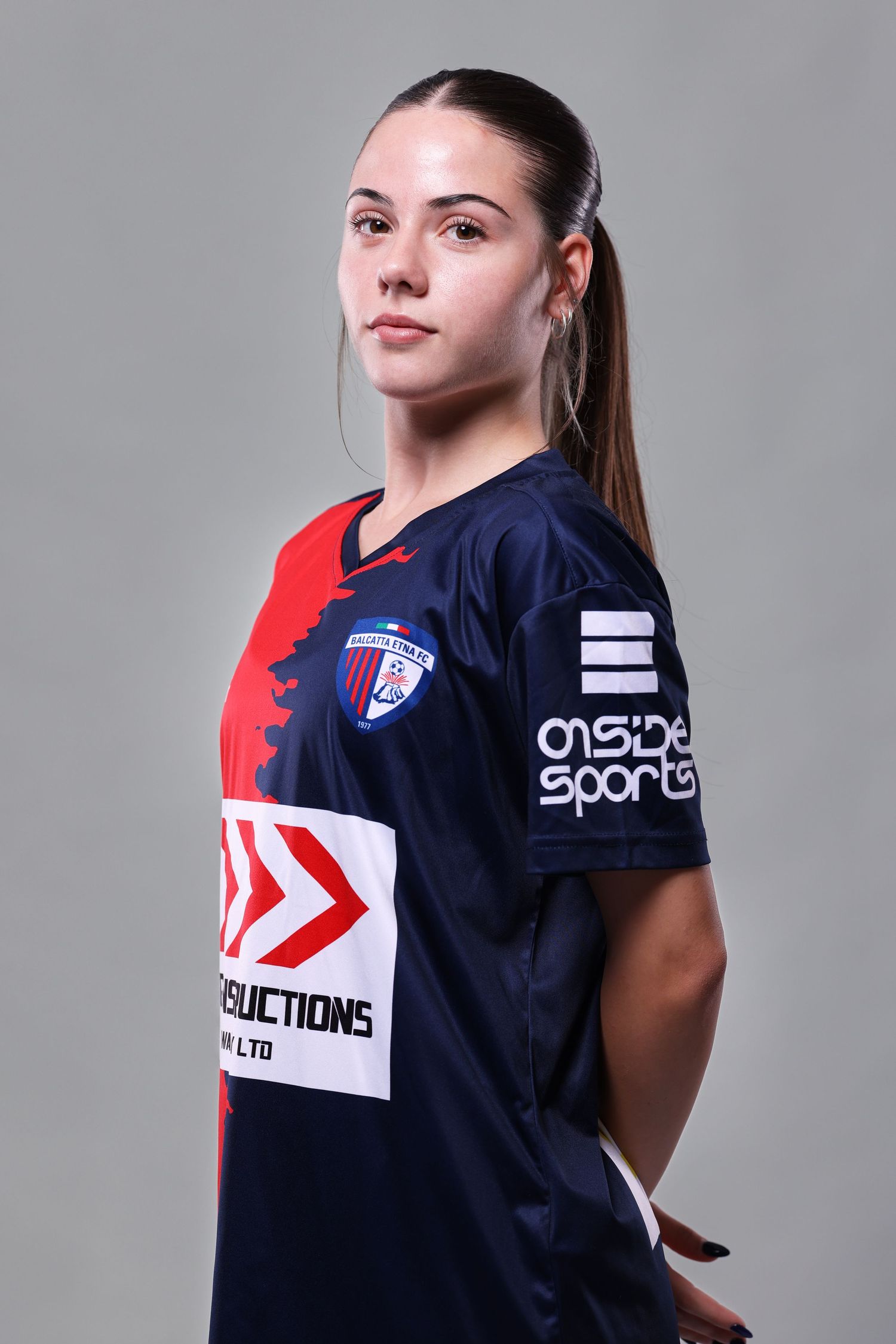 Athletic apparel product photography showing navy blue sports jersey with red accents and sponsor logos from multiple angles.