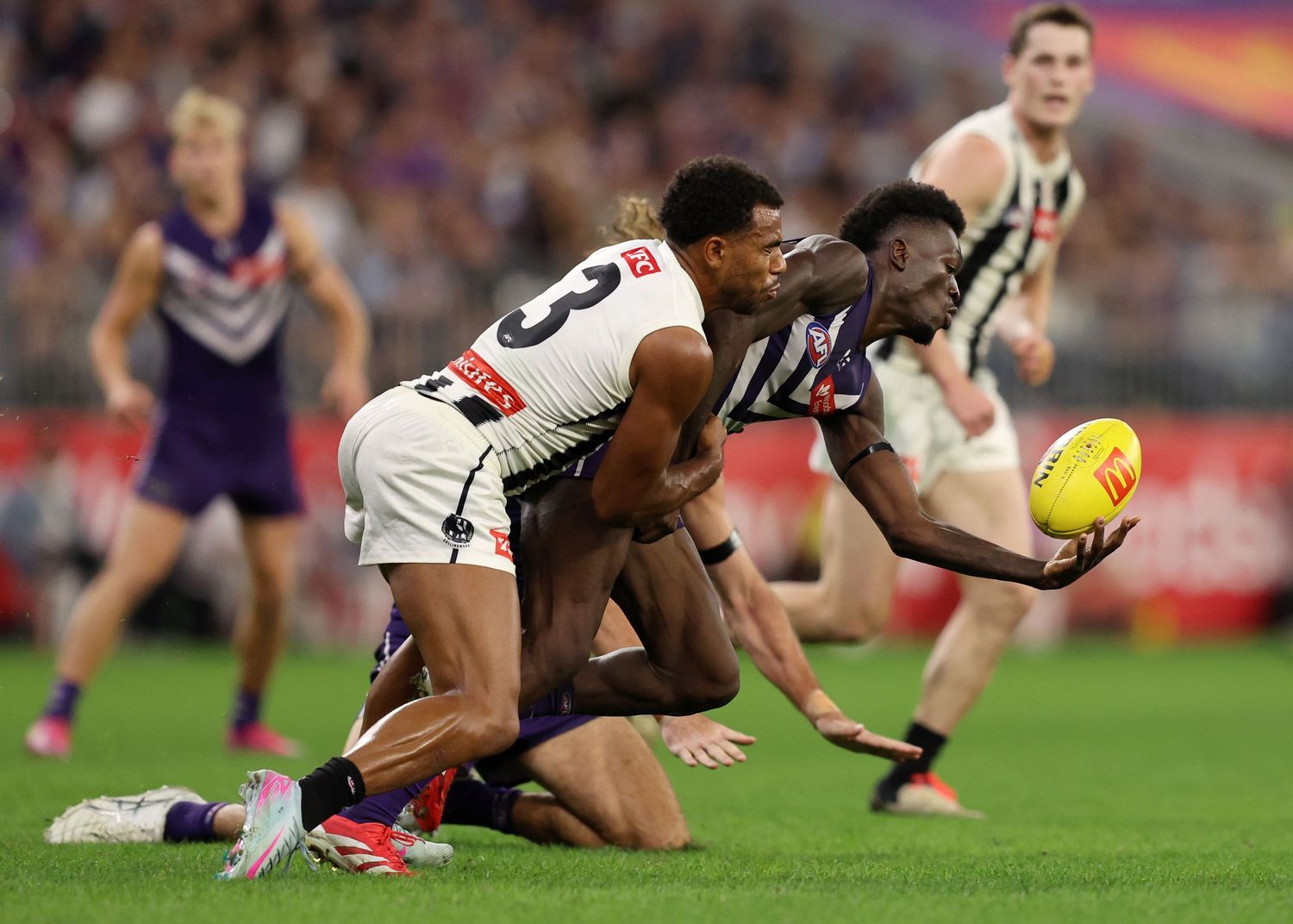 Two players collide while competing for the ball in AFL match.