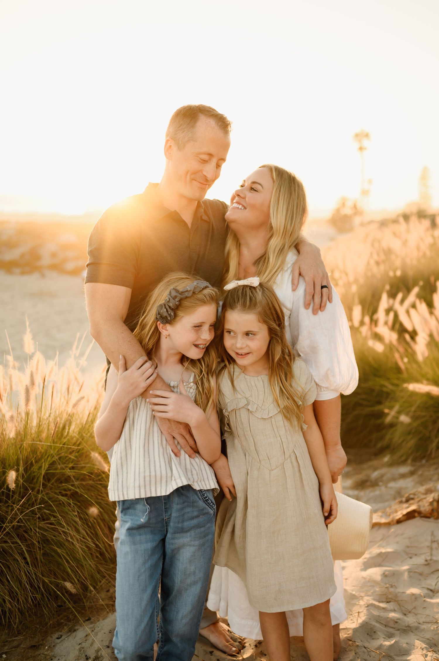 A family with two parents and two children smiling during Ventura beach family photoshoot by Thousand Oaks family photog