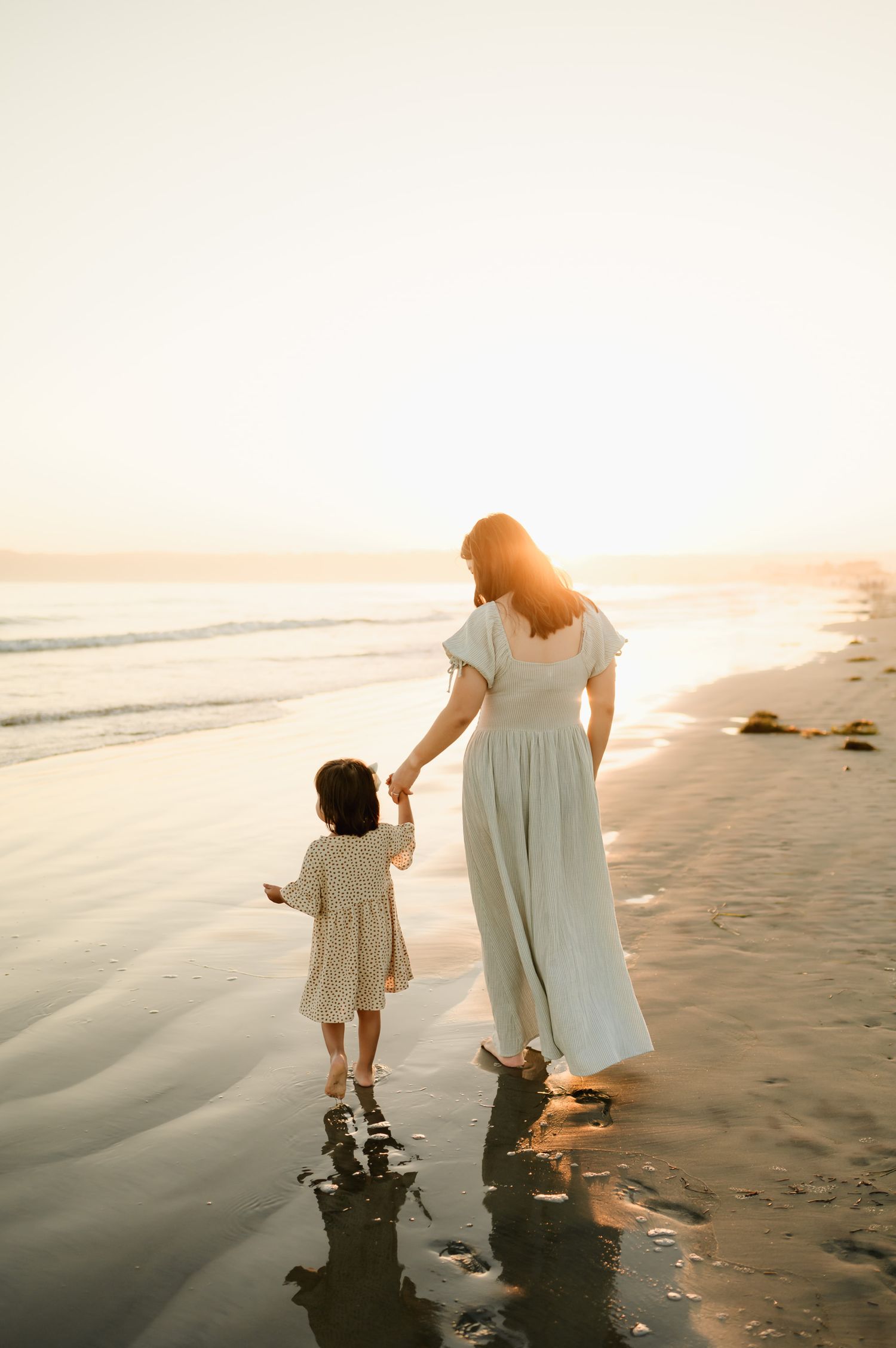 mom holding daughters hand during sunset coronado beach mommy & me photos by San Diego photographer, Tiffany Kelterer
