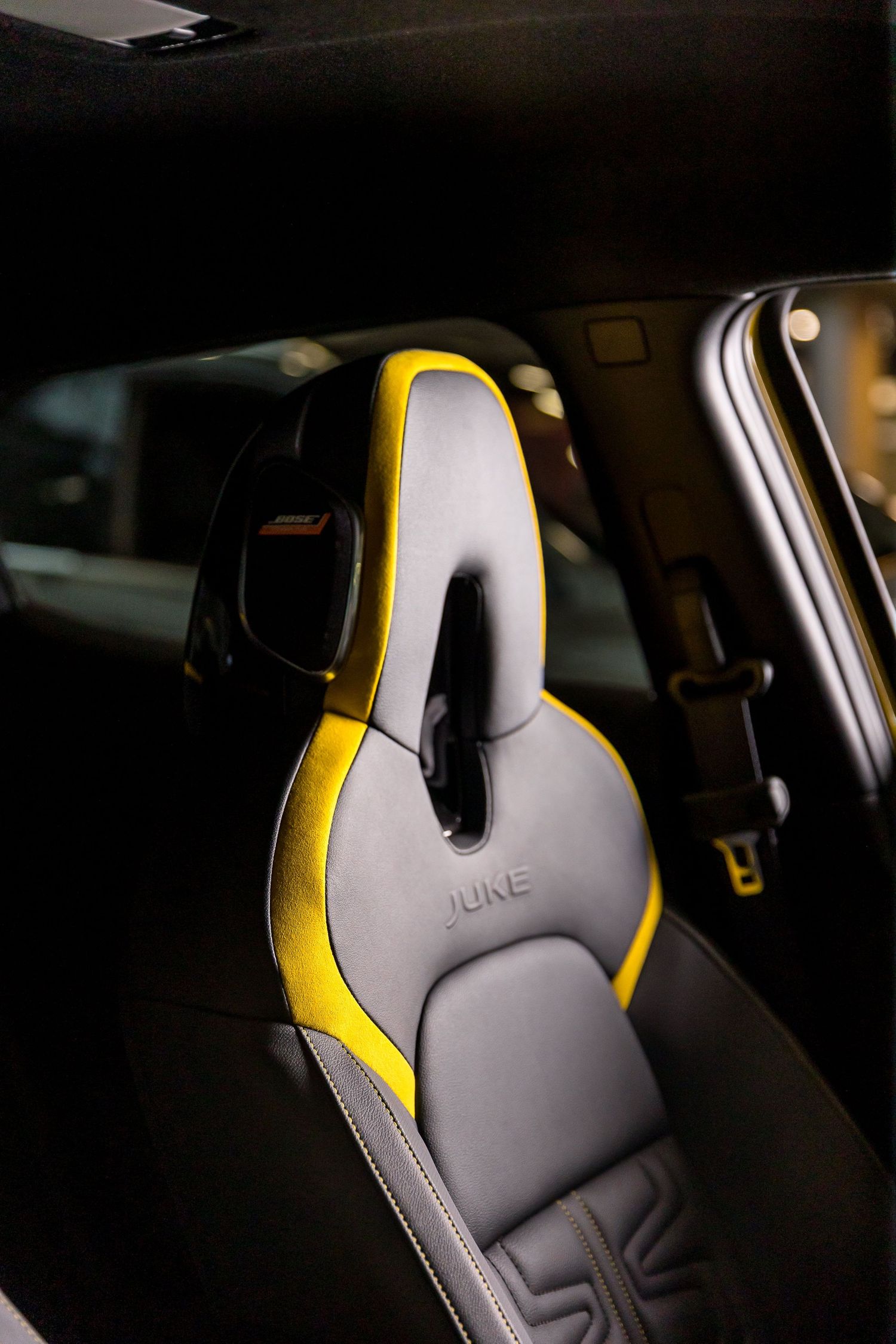 Nissan Juke interior sport seat in gray leather with yellow accents and black headrest detail.