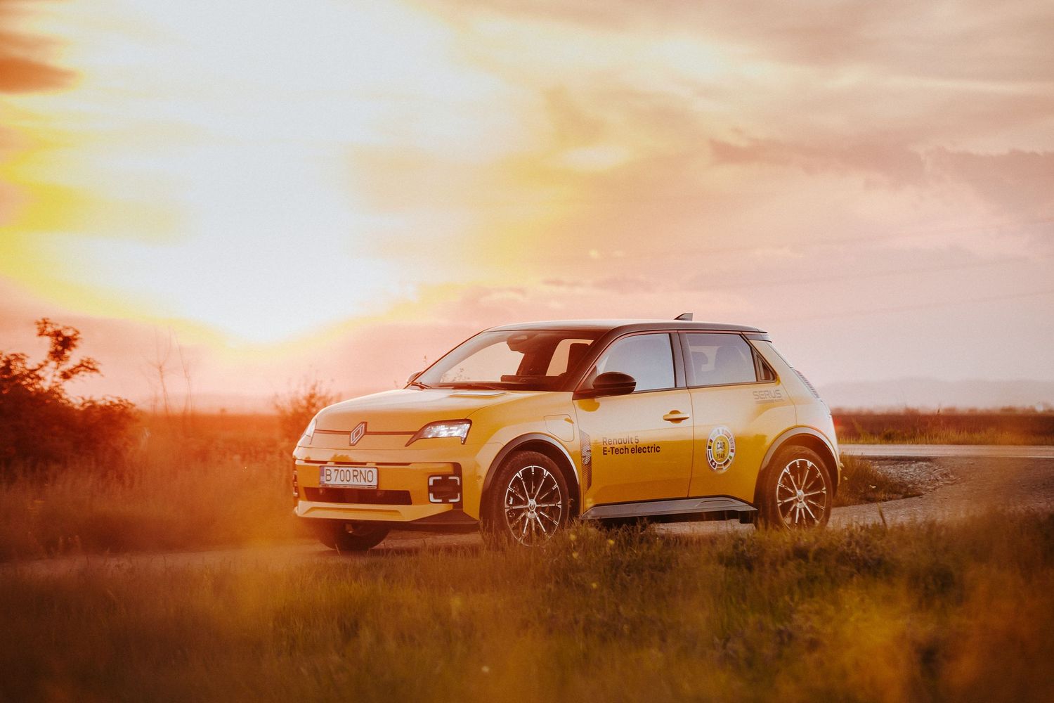 Yellow Citroen compact car parked at sunset in golden hour light.