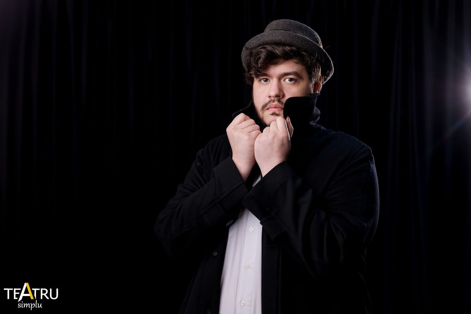 Man in flat cap and black jacket poses dramatically against dark background, Teatru logo visible.