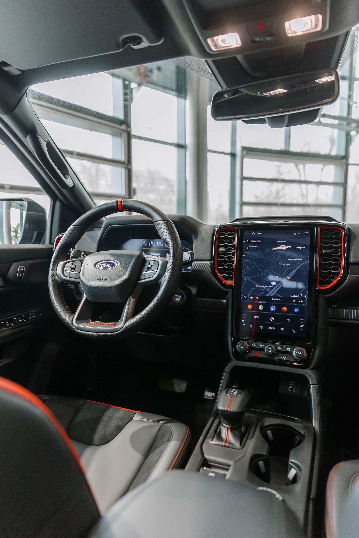 Ford truck interior featuring a large touchscreen infotainment system, sport steering wheel, and premium cabin design.