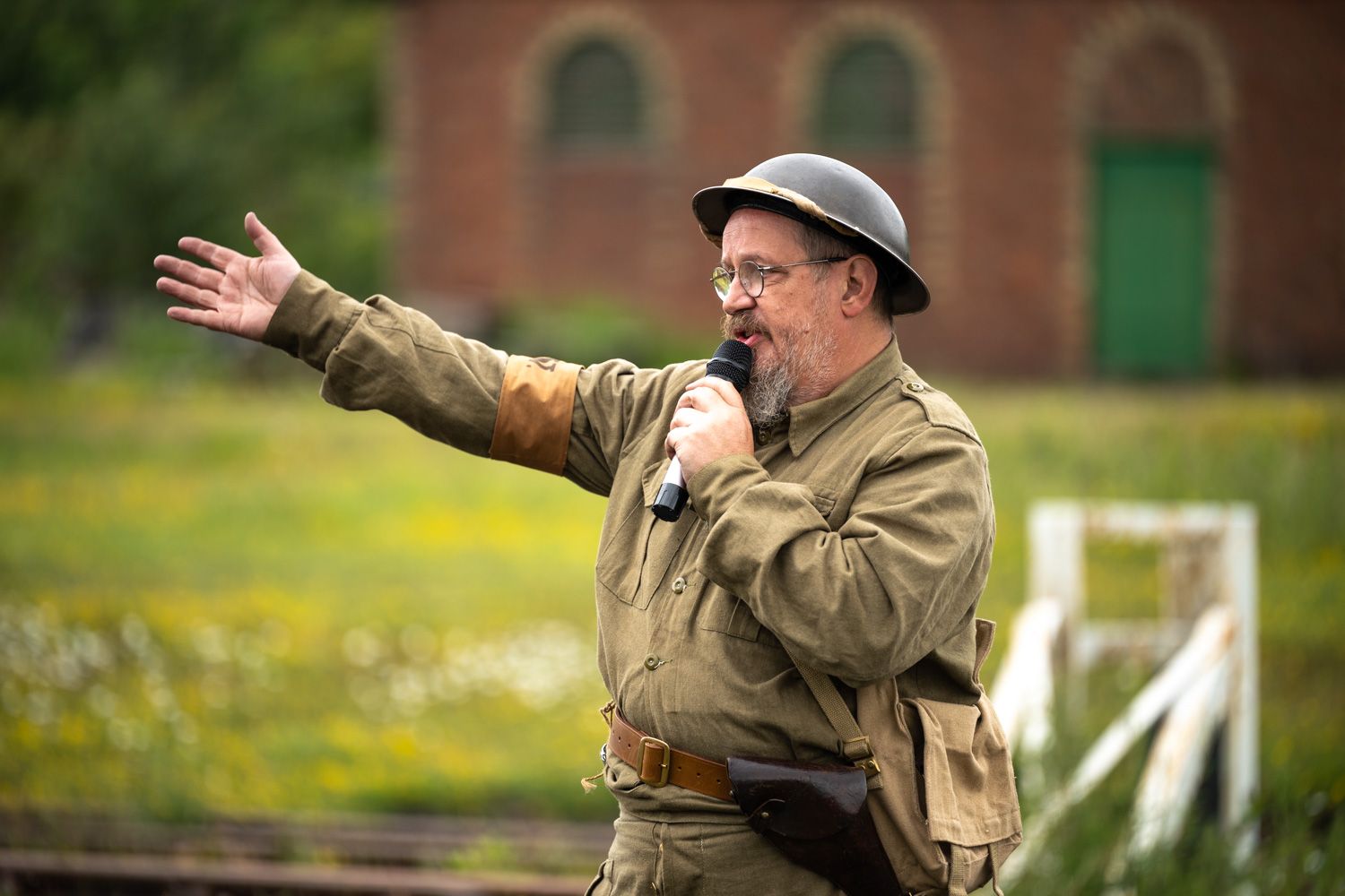 A man dressed in an old army uniform giving a speech to a crowd.
