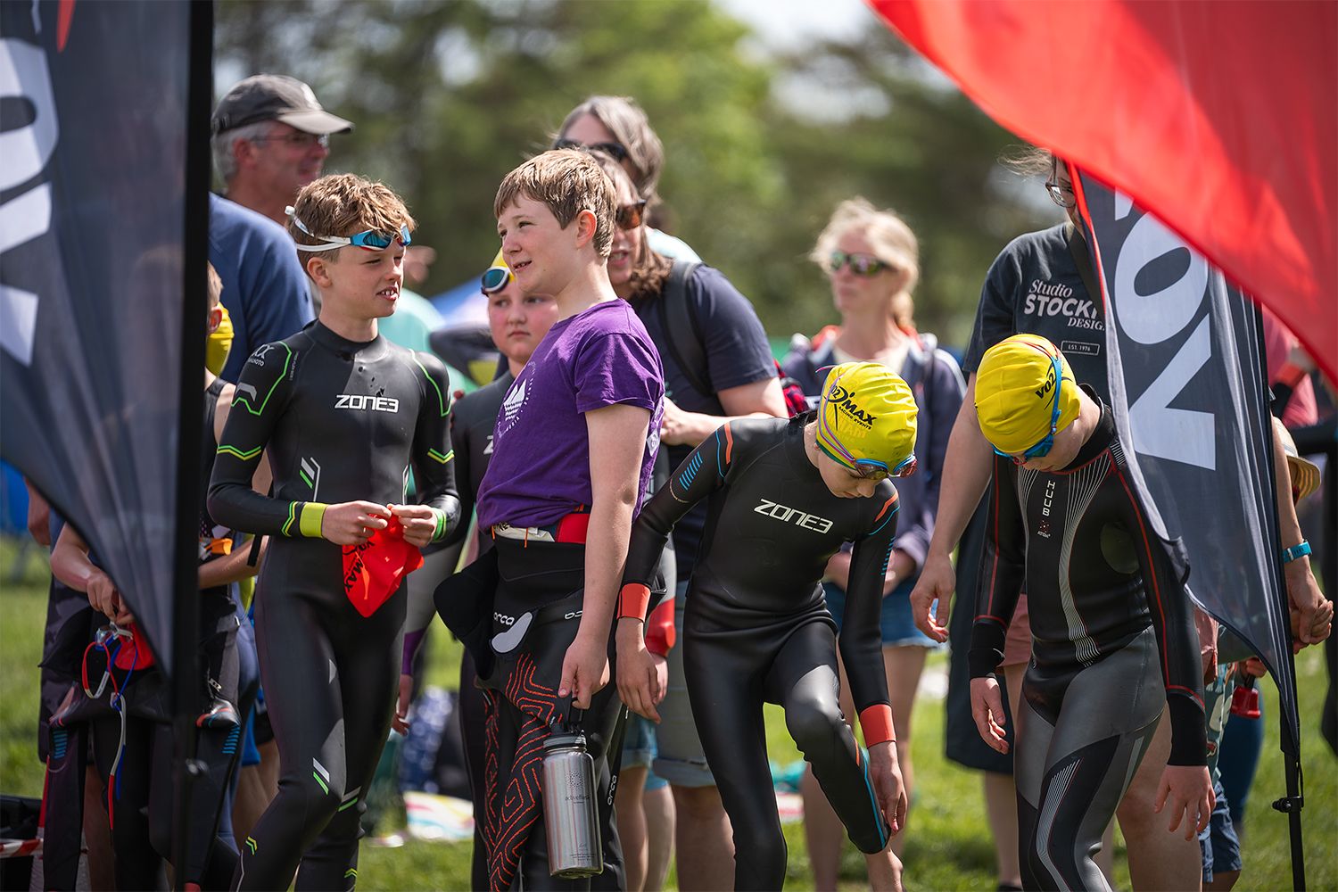 A group of young people waiting at the start line to start their swimming race event.