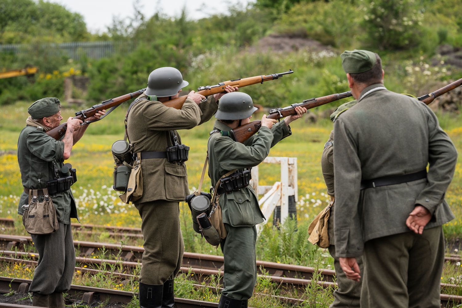 A firing demonstration in a field showcasing old weaponry from ww2.