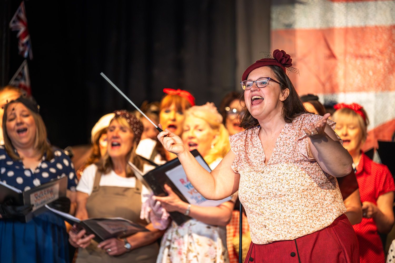 A composer and a choir singing on stage.
