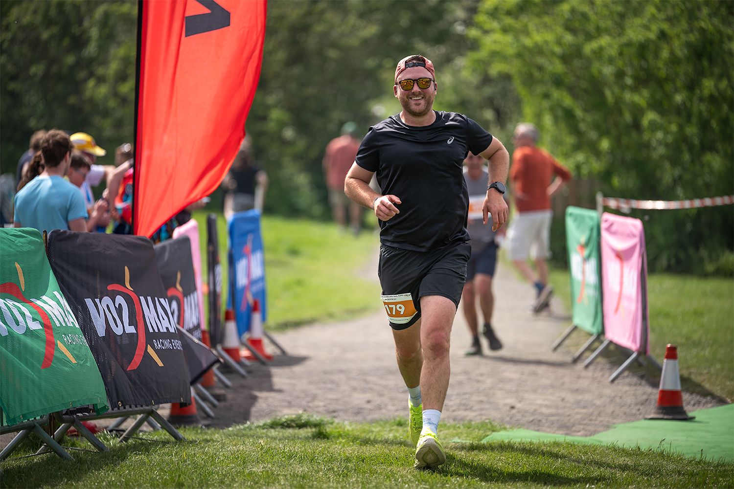 A man running up to the finish line of a triathlon event.