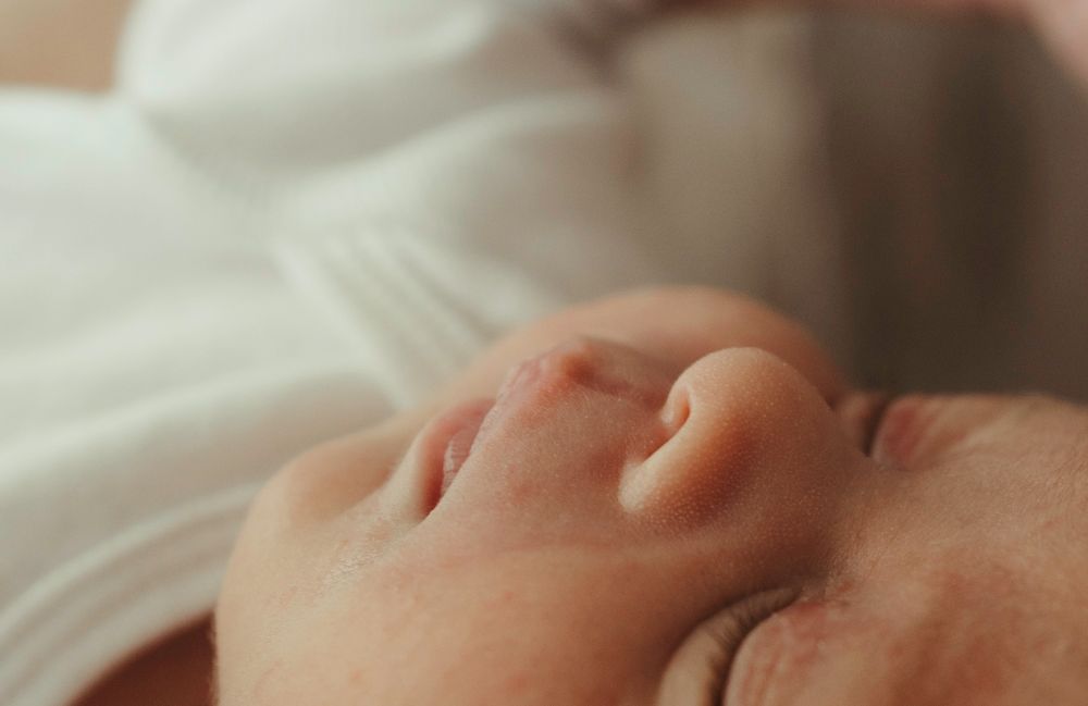 Extreme close-up of peaceful sleeping newborn baby's face and ear.