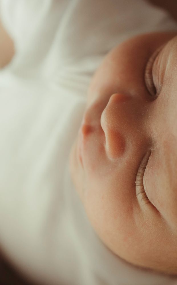 Ultra close-up macro shot of sleeping newborn baby's nose and cheek.