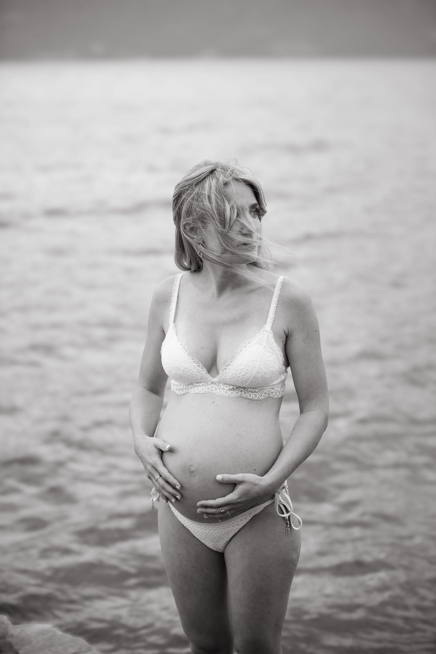 Femme enceinte photographiée en noir et blanc au bord du lac, lors d’une séance grossesse à Vevey.