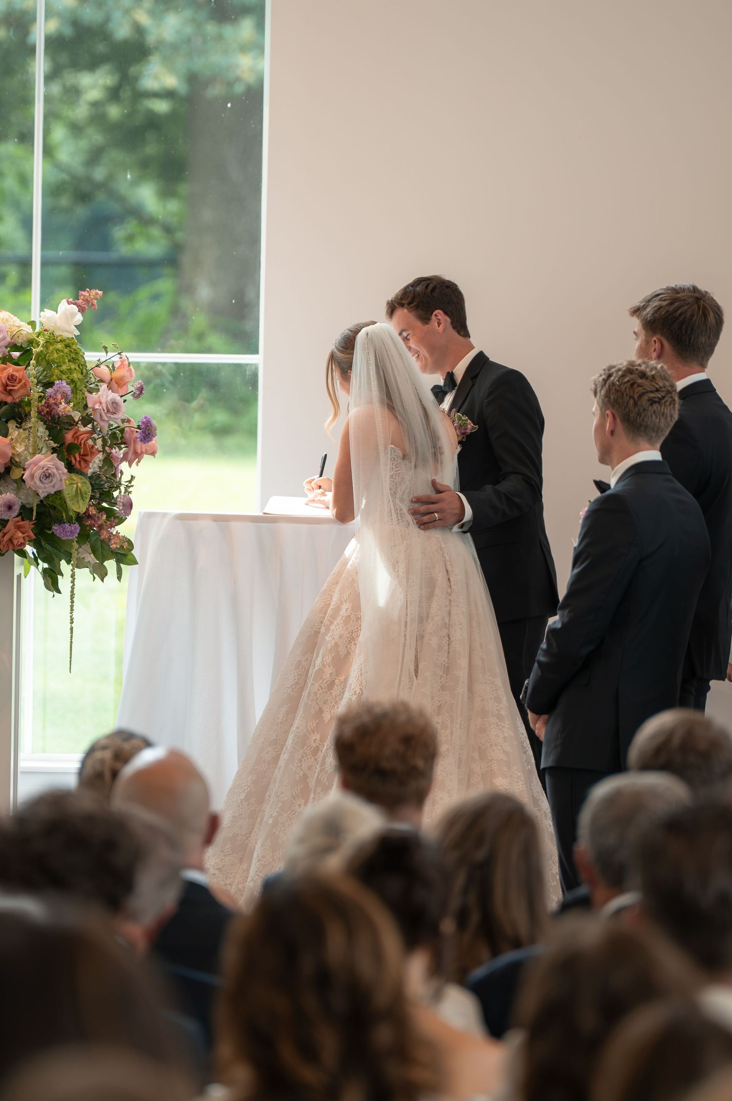 Bride and groom share first kiss at altar during intimate wedding ceremony.