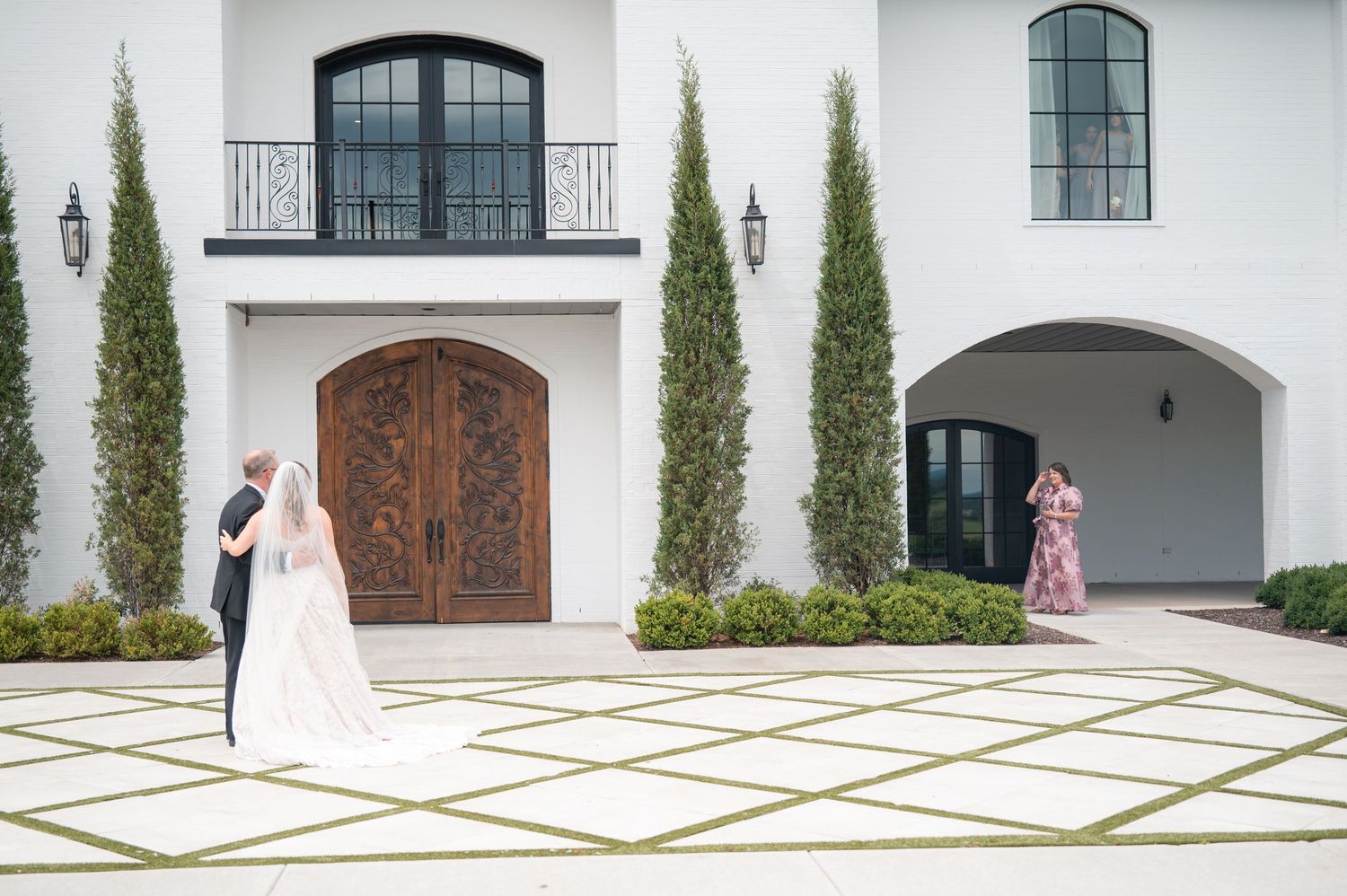 Bride and groom sharing first look outside elegant white wedding venue.