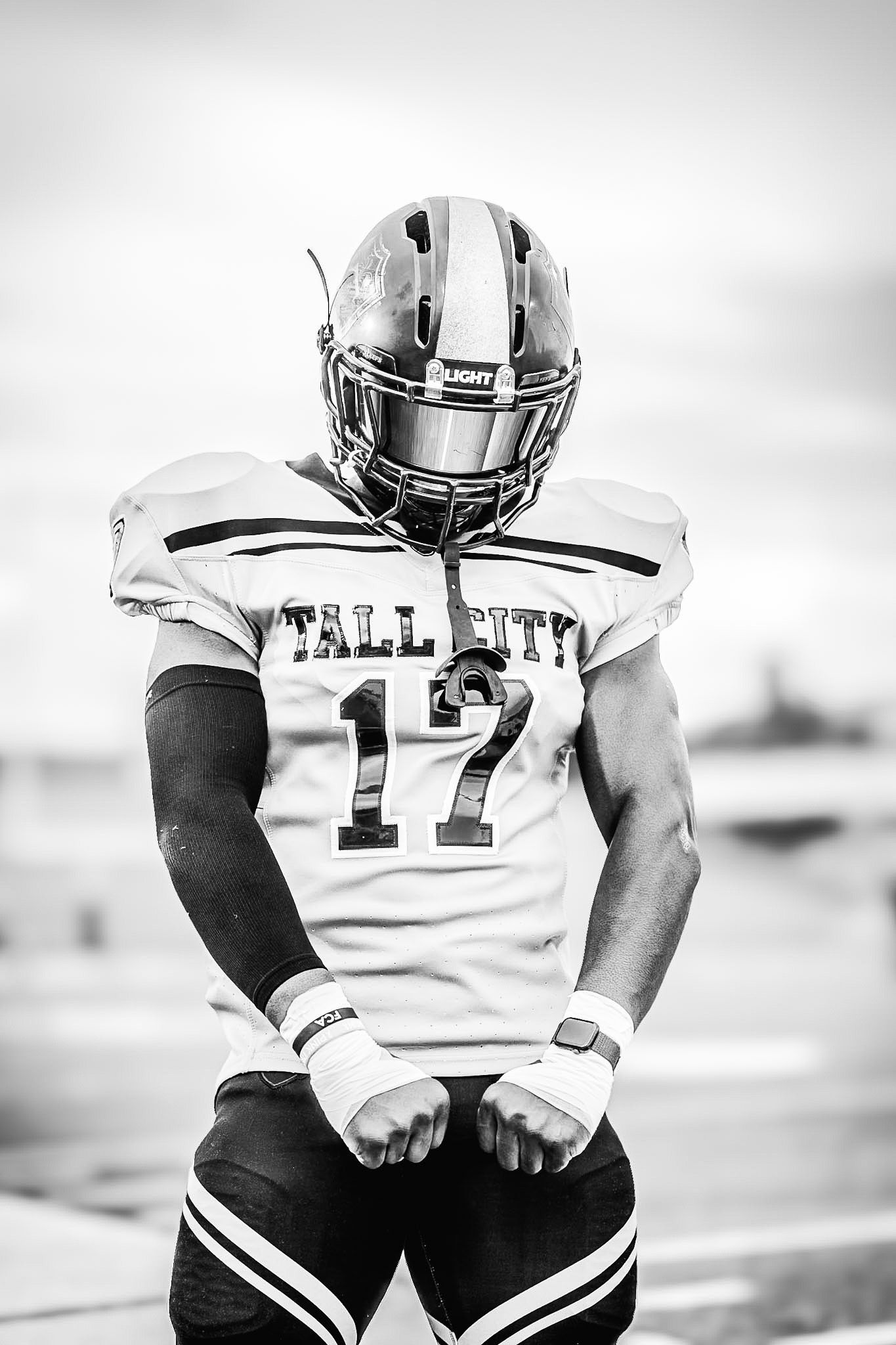 Black and white portrait of Tall City number 17 football player in full uniform and helmet.