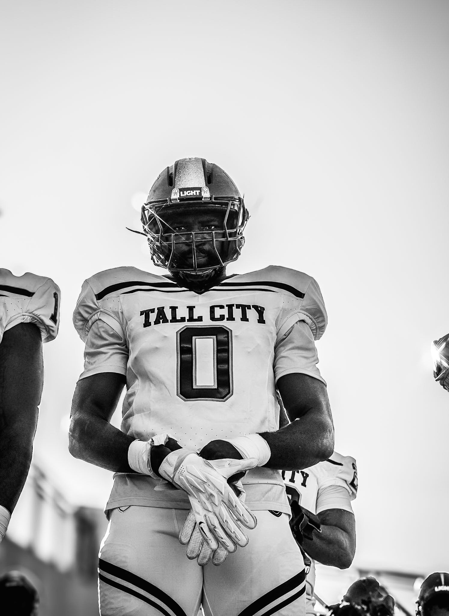 Football player wearing Tall City number 0 jersey stands ready in black and white pregame photo.