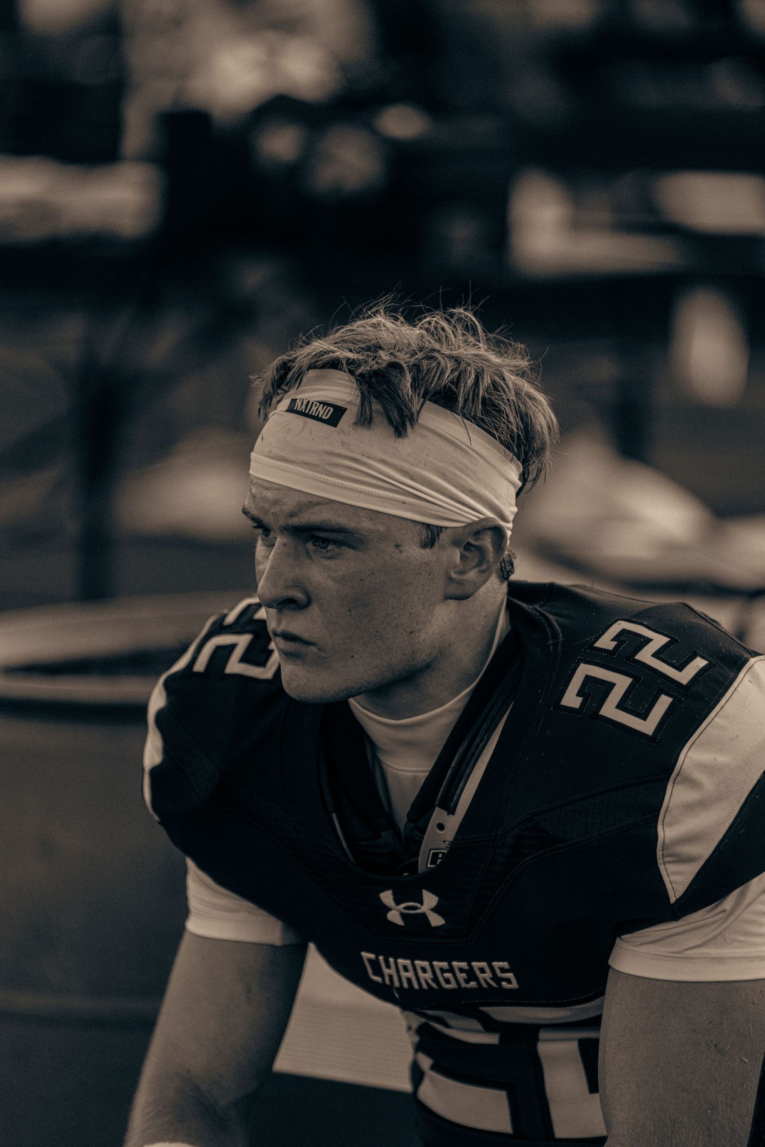 Black and white photo of a young football player wearing a Chargers jersey number 22 with a white headband.