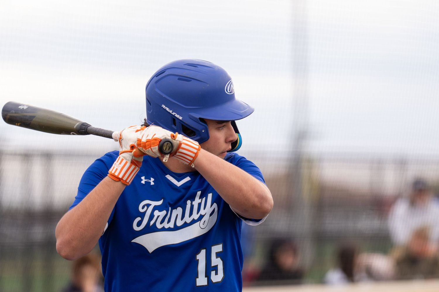 Trinity baseball player #15 in blue helmet bats during a game.