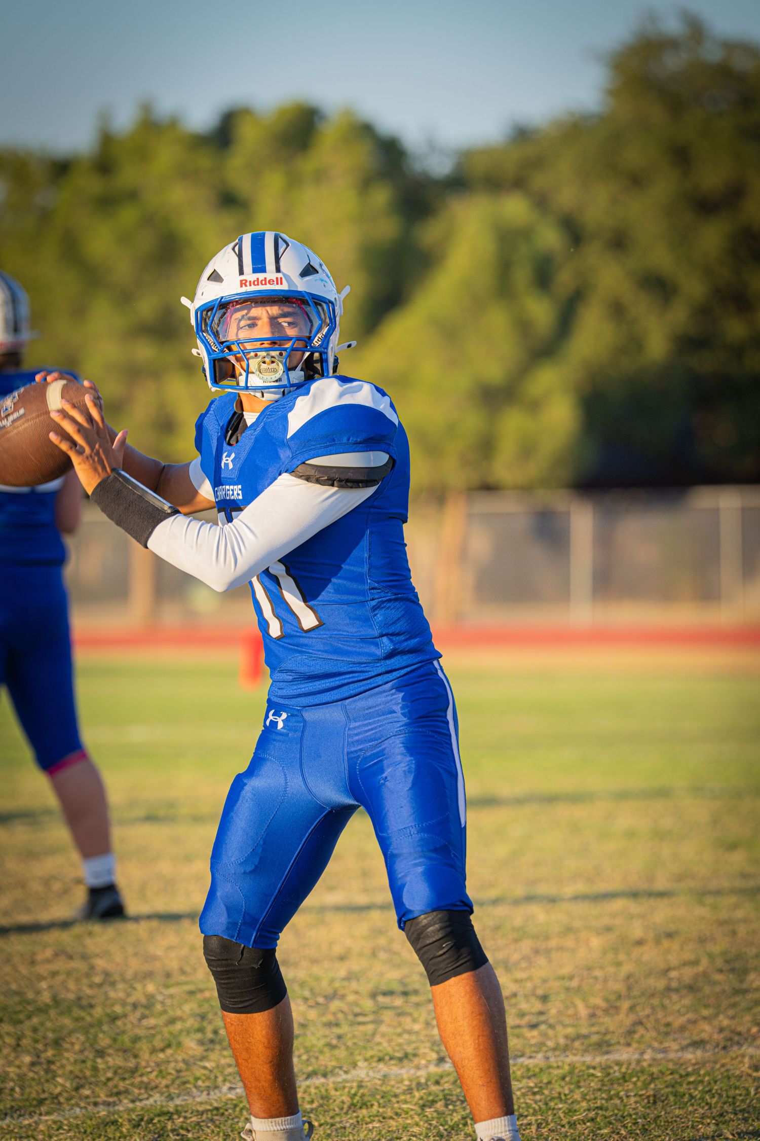 Trinity football quarterback #11 in blue prepares to throw a pass.