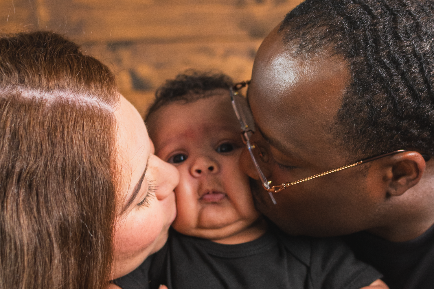Professional studio newborn session in Edmonton.

Parents kissing their baby for the photo