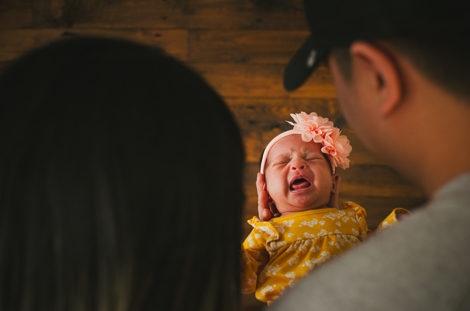 Professional studio newborn session in Edmonton with natural light.

Capturing a moment of the baby crying and parents watching