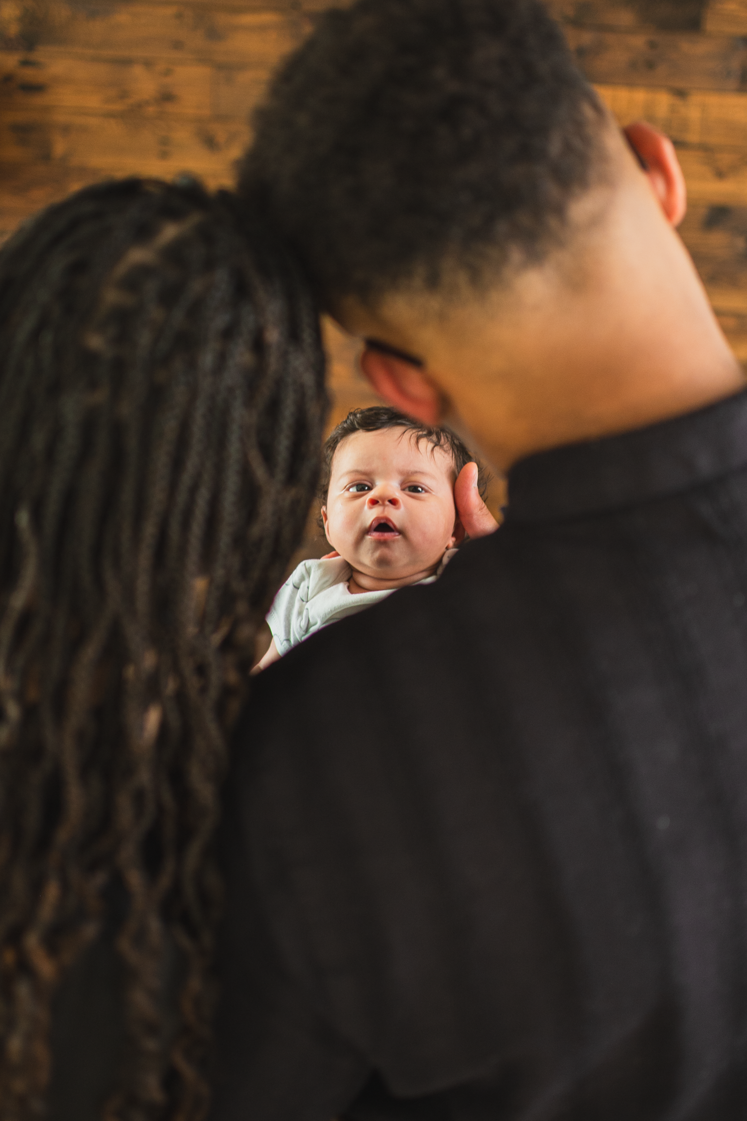 Parents holding and watching their newborn baby during a lifestyle studio session in Edmonton.

creative shot
