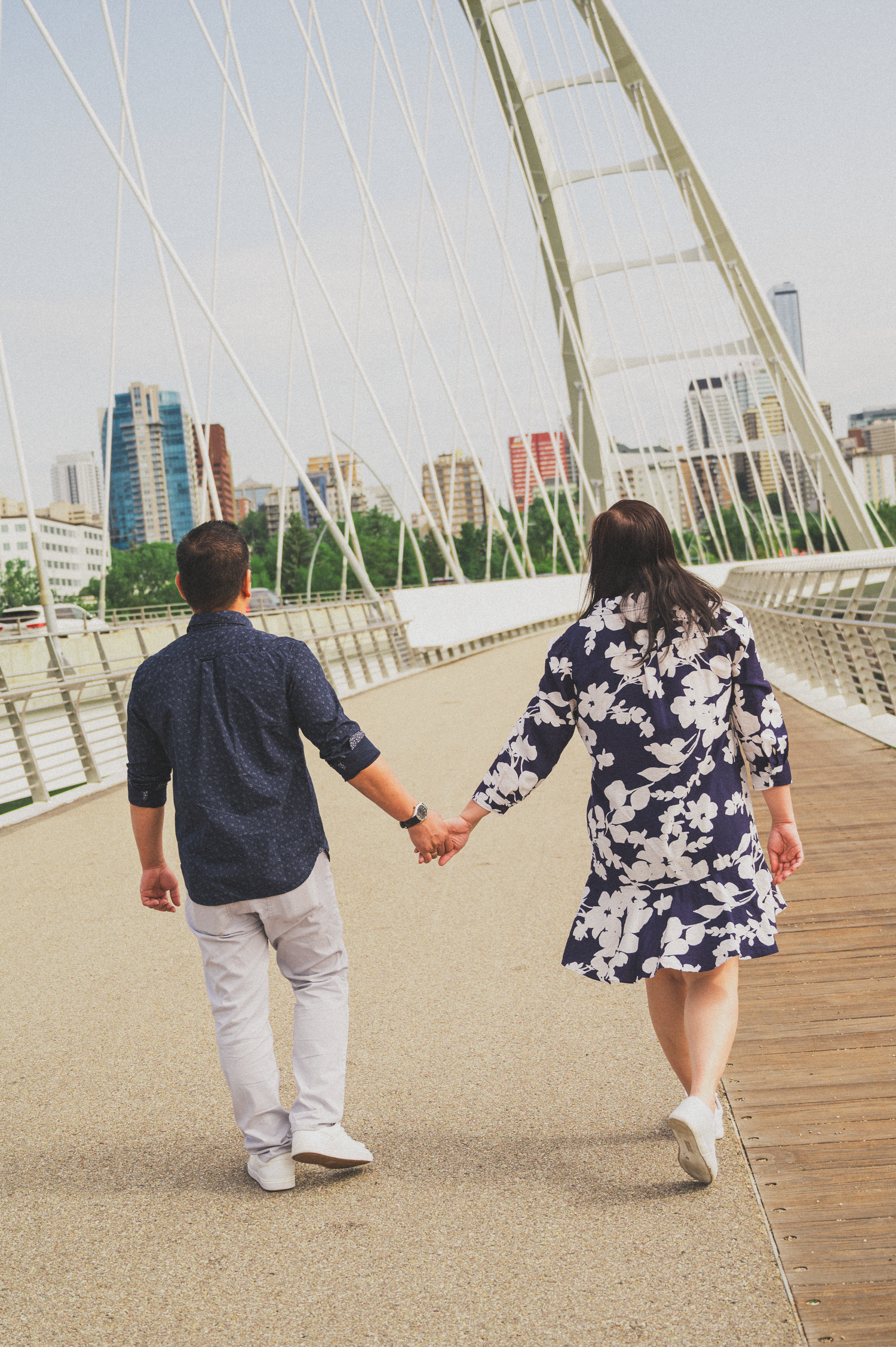 A moment captured of a couple walking together holding hands during a summer session in Edmonton.