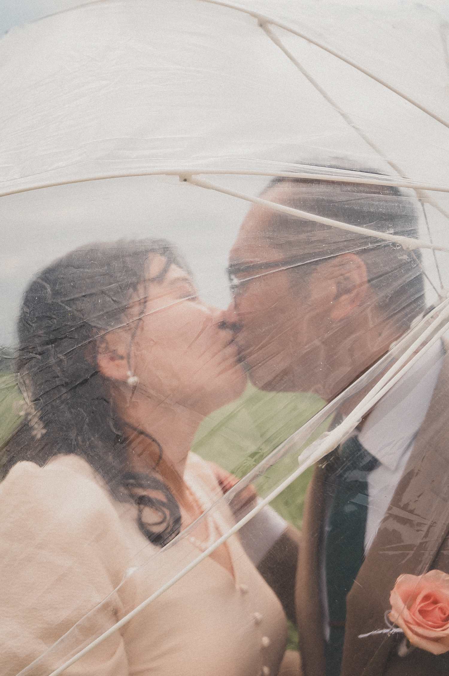 Couple kissing behind the clear umbrella after the wedding in Edmonton.