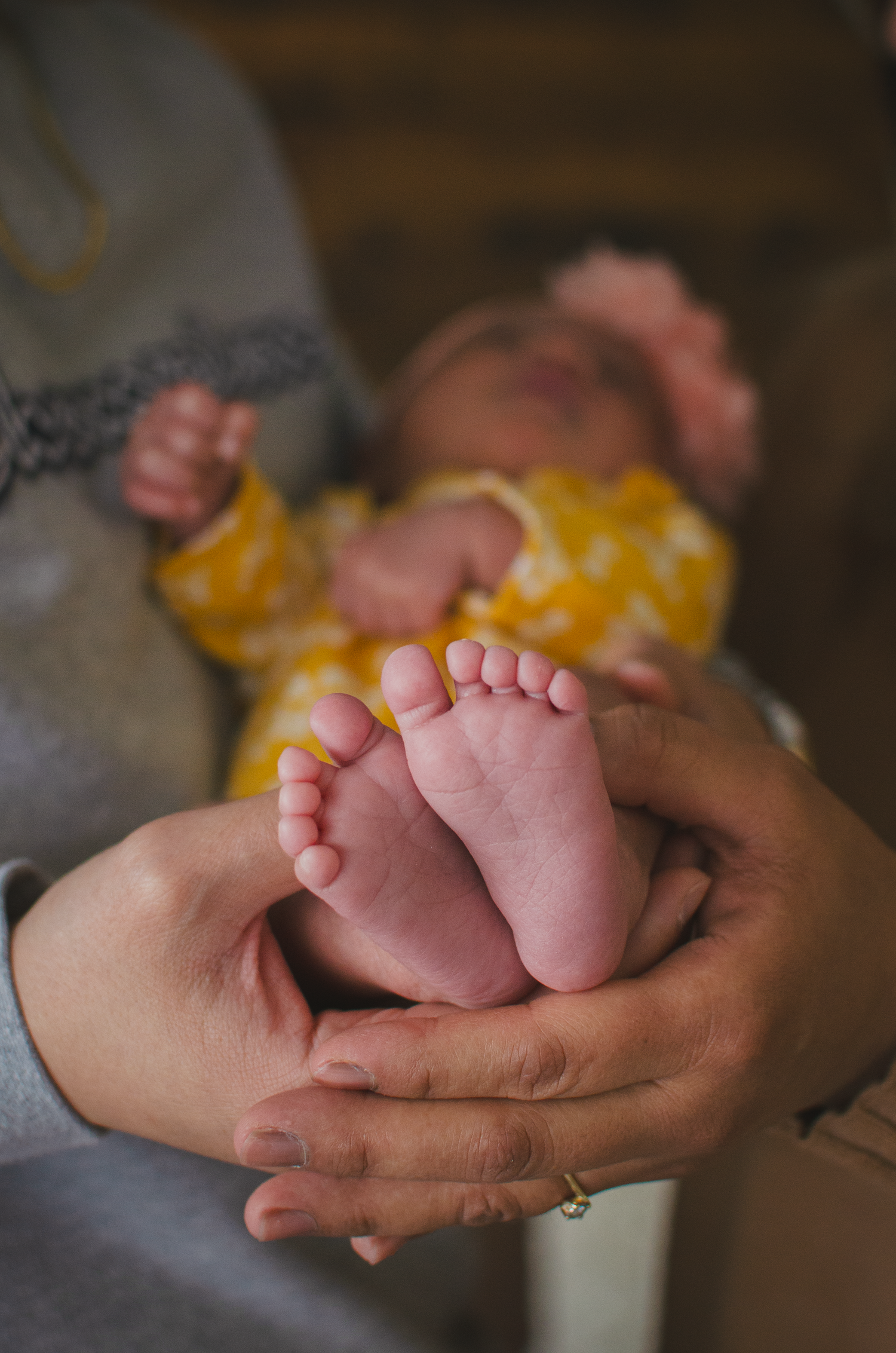 Parents holding their newborn baby, showing her cute feet during a lifestyle studio session in Edmonton.

creative shot