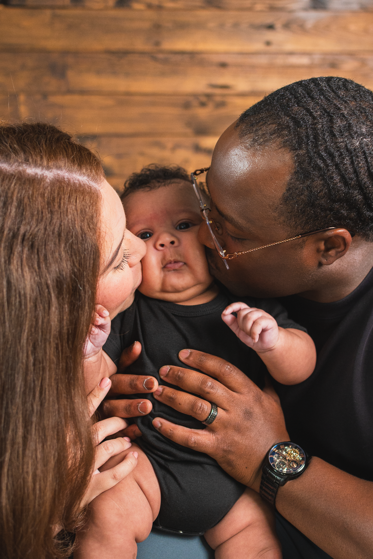 Professional studio newborn session in Edmonton.

Parents kissing their baby for the photo