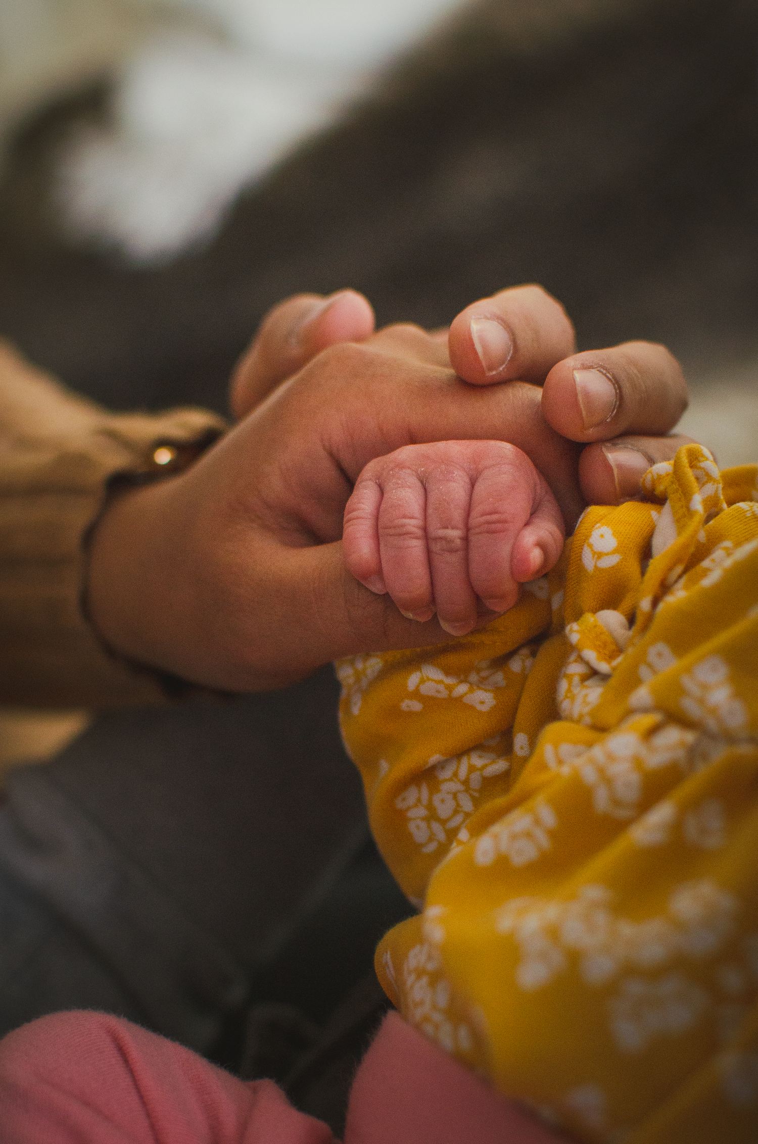 Parents holding their newborn baby, showing her cute hand during a lifestyle studio session in Edmonton.

creative shot