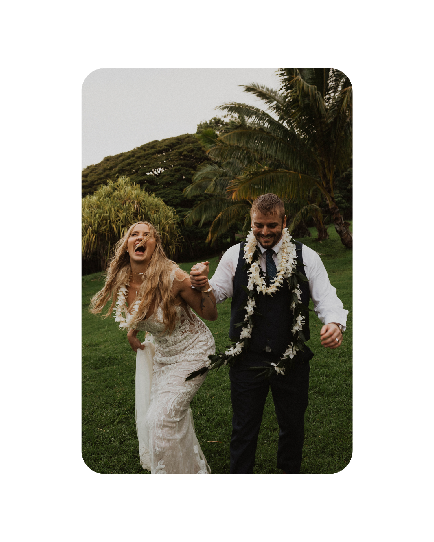 A couple laughs and dances together outdoors in wedding attire surrounded by lush greenery and natural lighting.