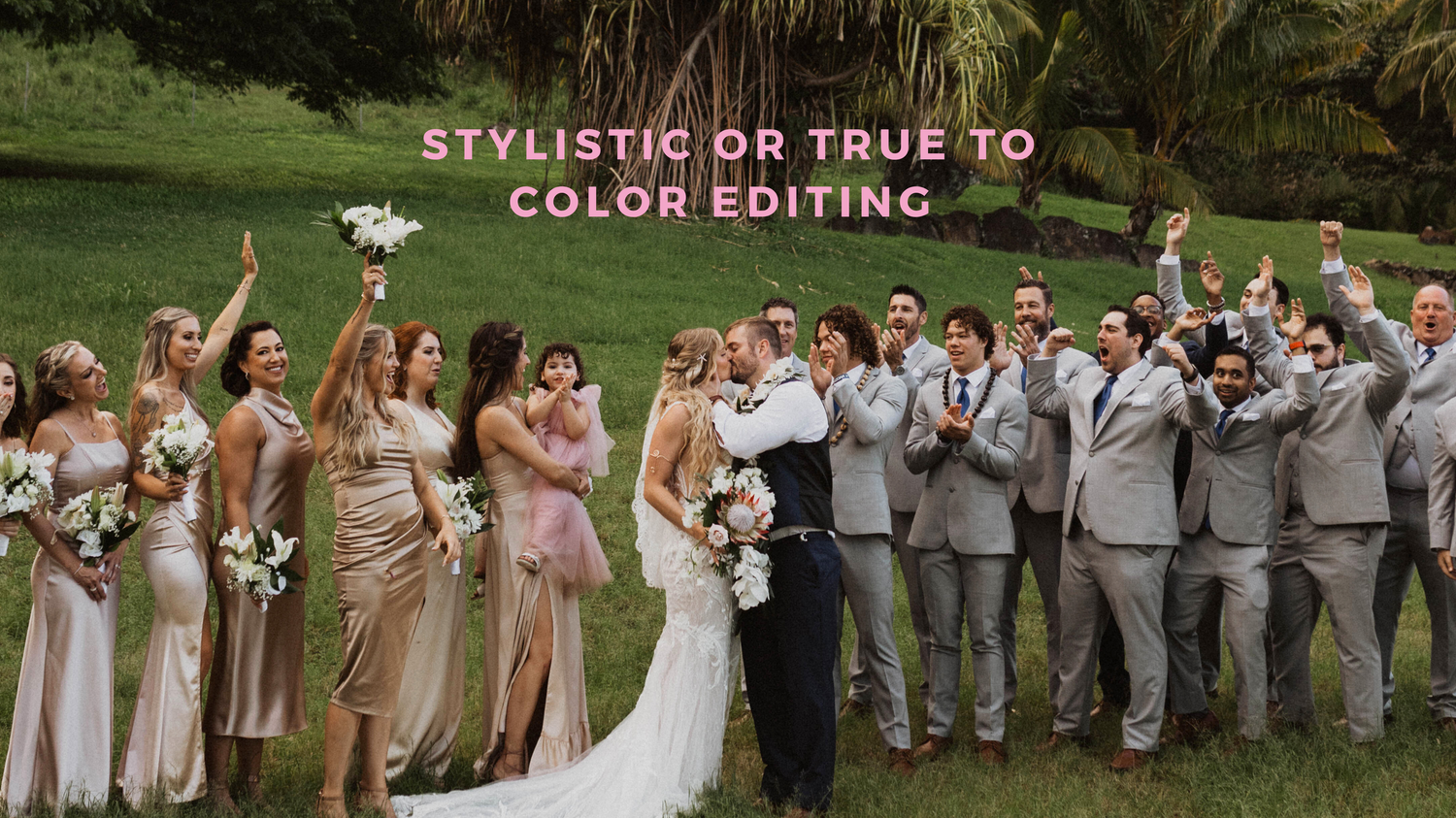 Wedding party stands outdoors in a line wearing pink dresses and gray suits with arms raised in celebration.