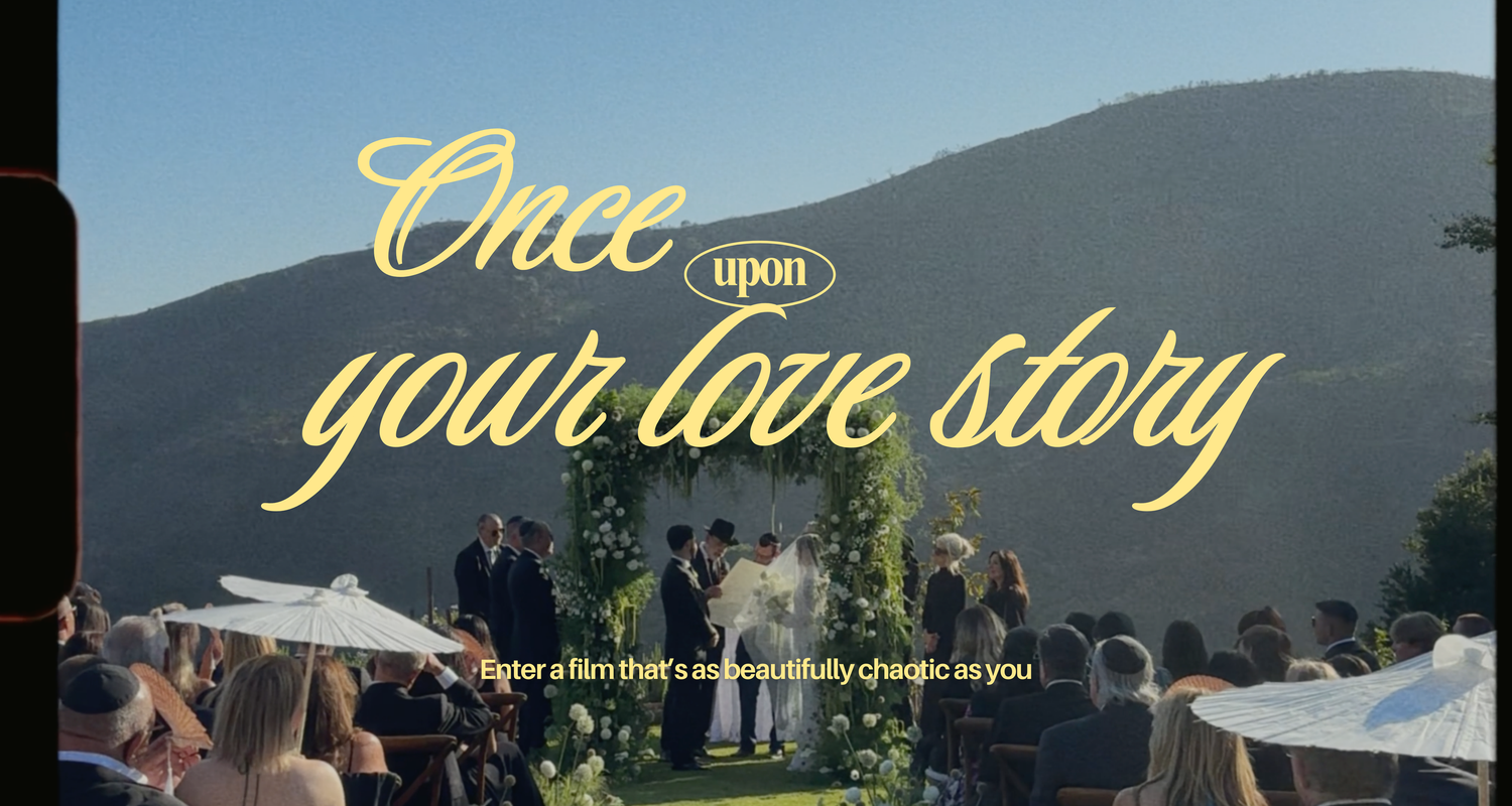 Illuminated wedding reception setup under string lights and white tents at sunset with mountain views in the background.