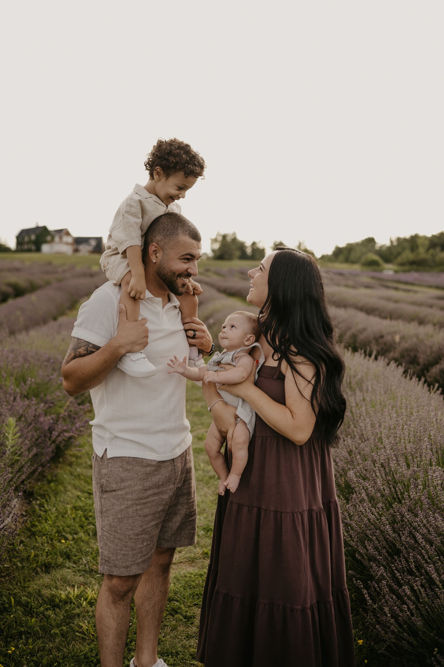Happy family with two young children laughing together in a lavender field.