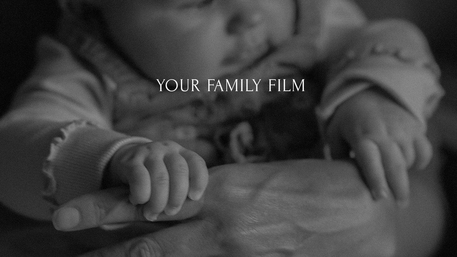 Black and white close-up photograph of a newborn baby’s tiny hands holding onto their mother’s fingers. Text over it saying Your Family Film