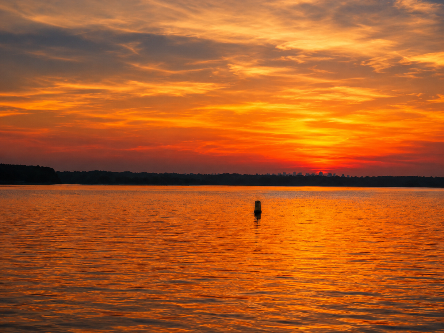 Orange sunset over water
Orange and red sunset reflecting across calm water beneath a glowing sky.