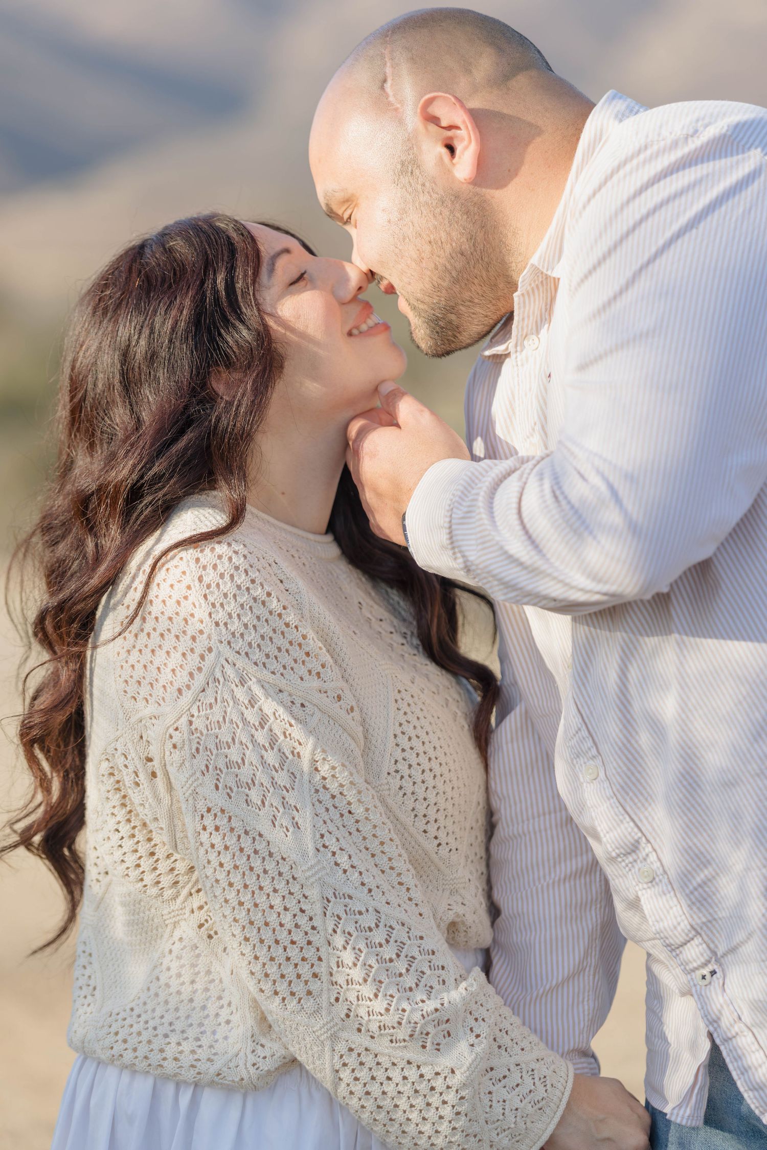 Man and woman sharing a tender nose-to-nose moment during a sunset couples session in San Diego