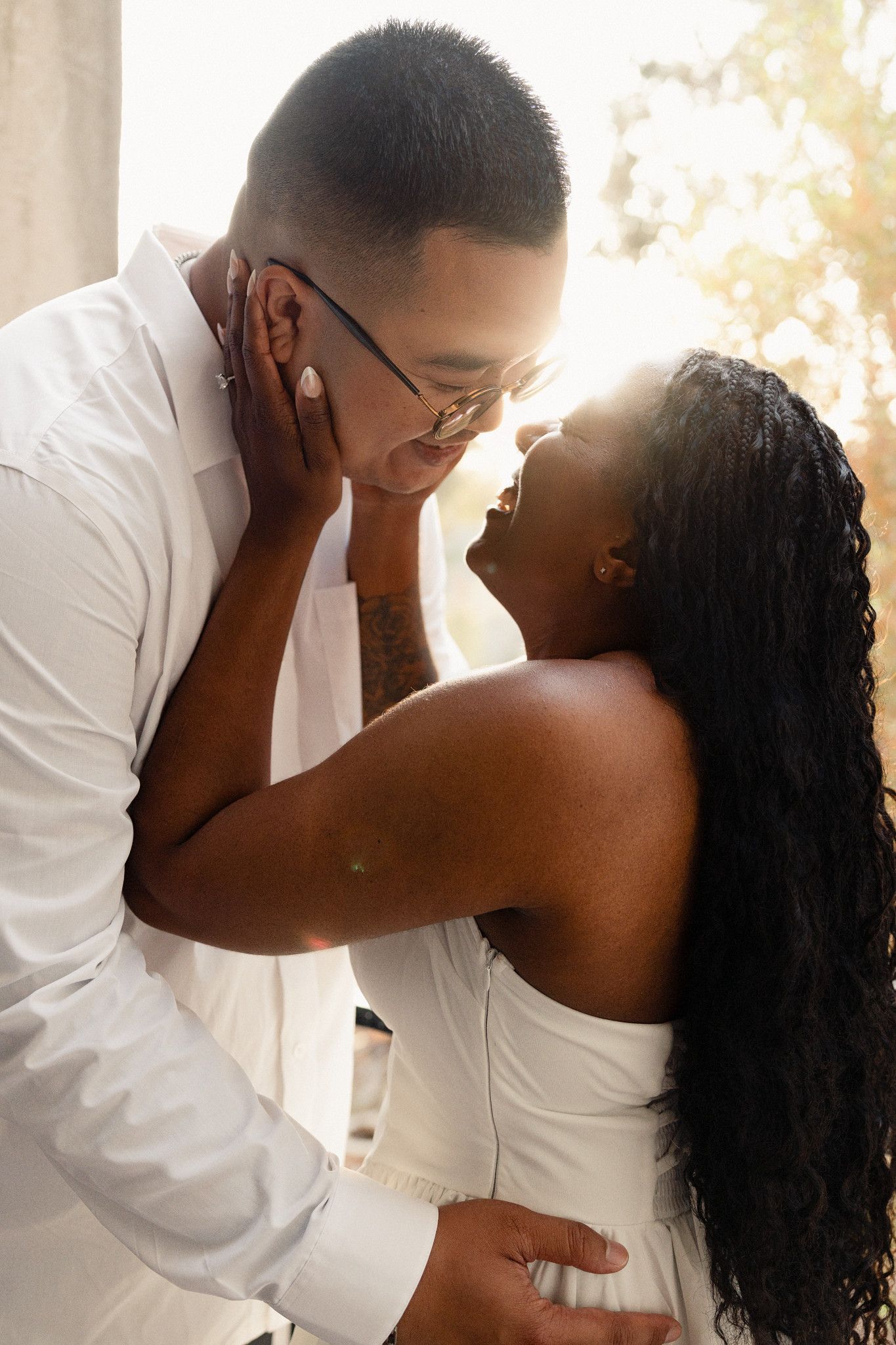 Couple laughing and embracing during an engagement session in San Diego at golden hour