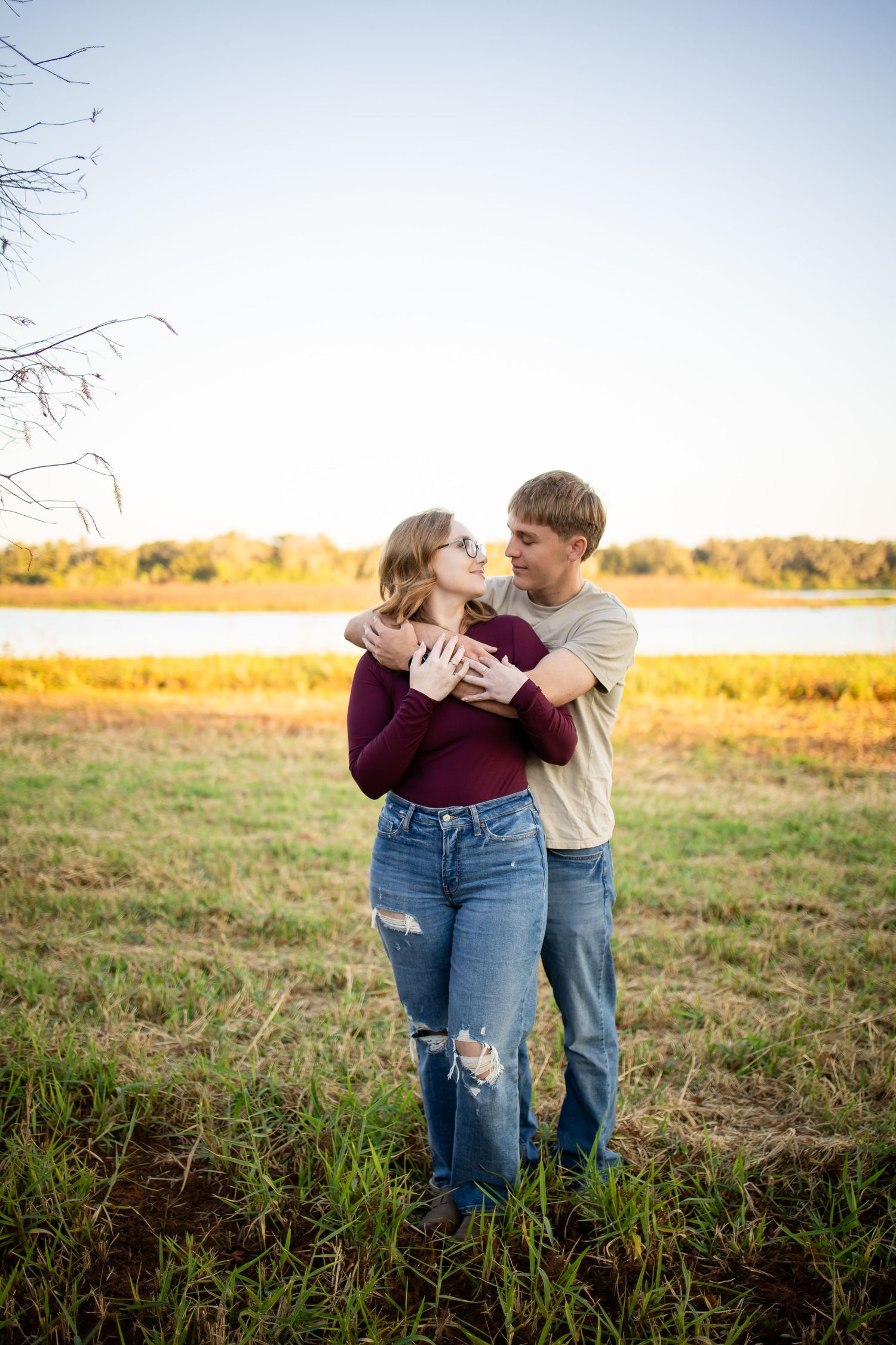 Couple sharing an intimate moment in a golden field during sunset.