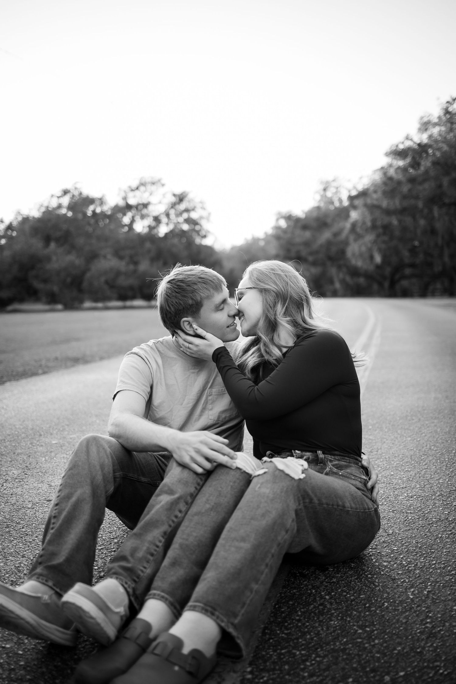 A black and white photo series of a couple lying together on the ground sharing intimate moments.