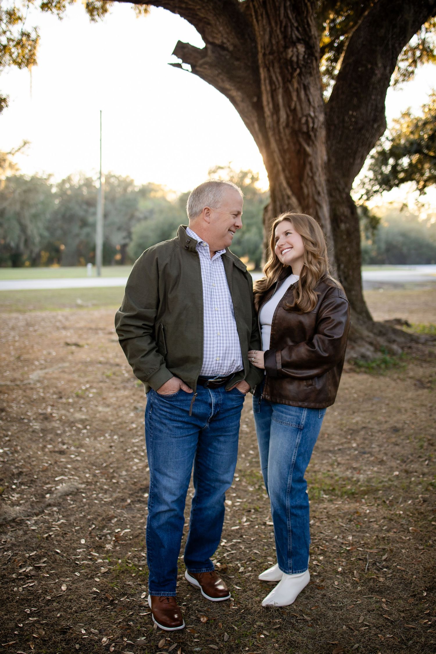 Candid moment between two people chatting under a majestic oak tree.