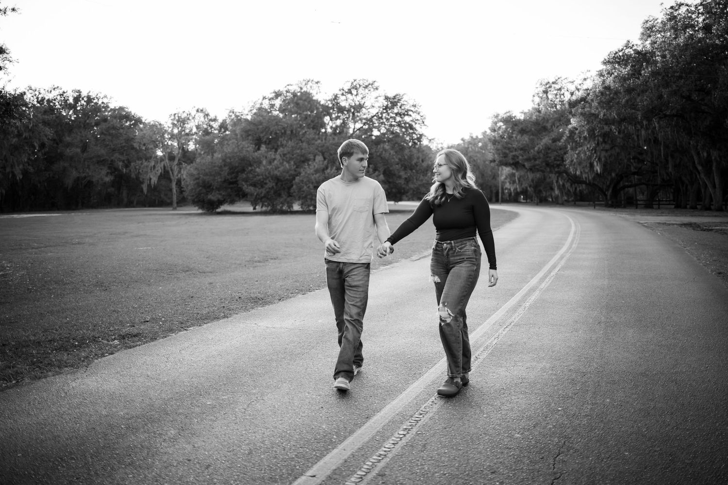Black and white photo of a couple walking together on a rural road.