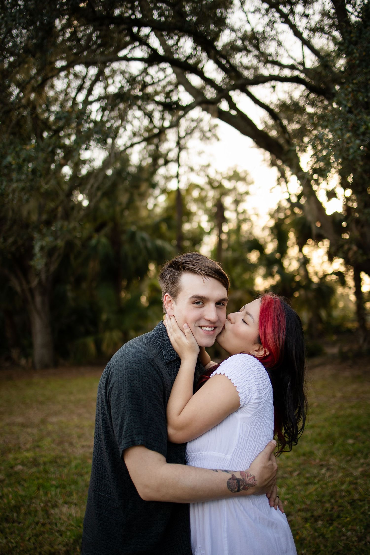 A couple shares tender moments together in a natural outdoor setting during golden hour.