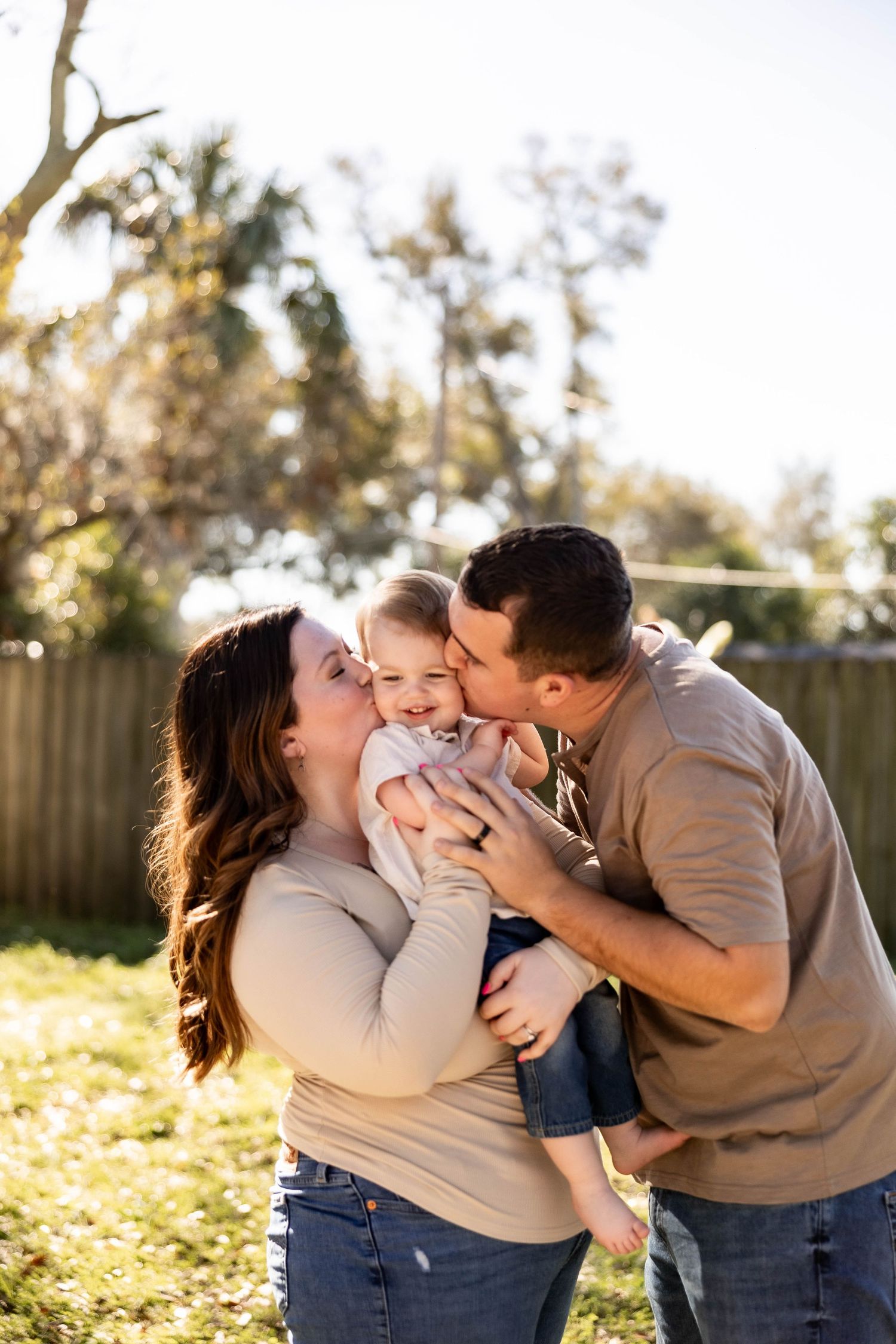 Family shares tender moment in outdoor photoshoot during sunset in backyard setting.