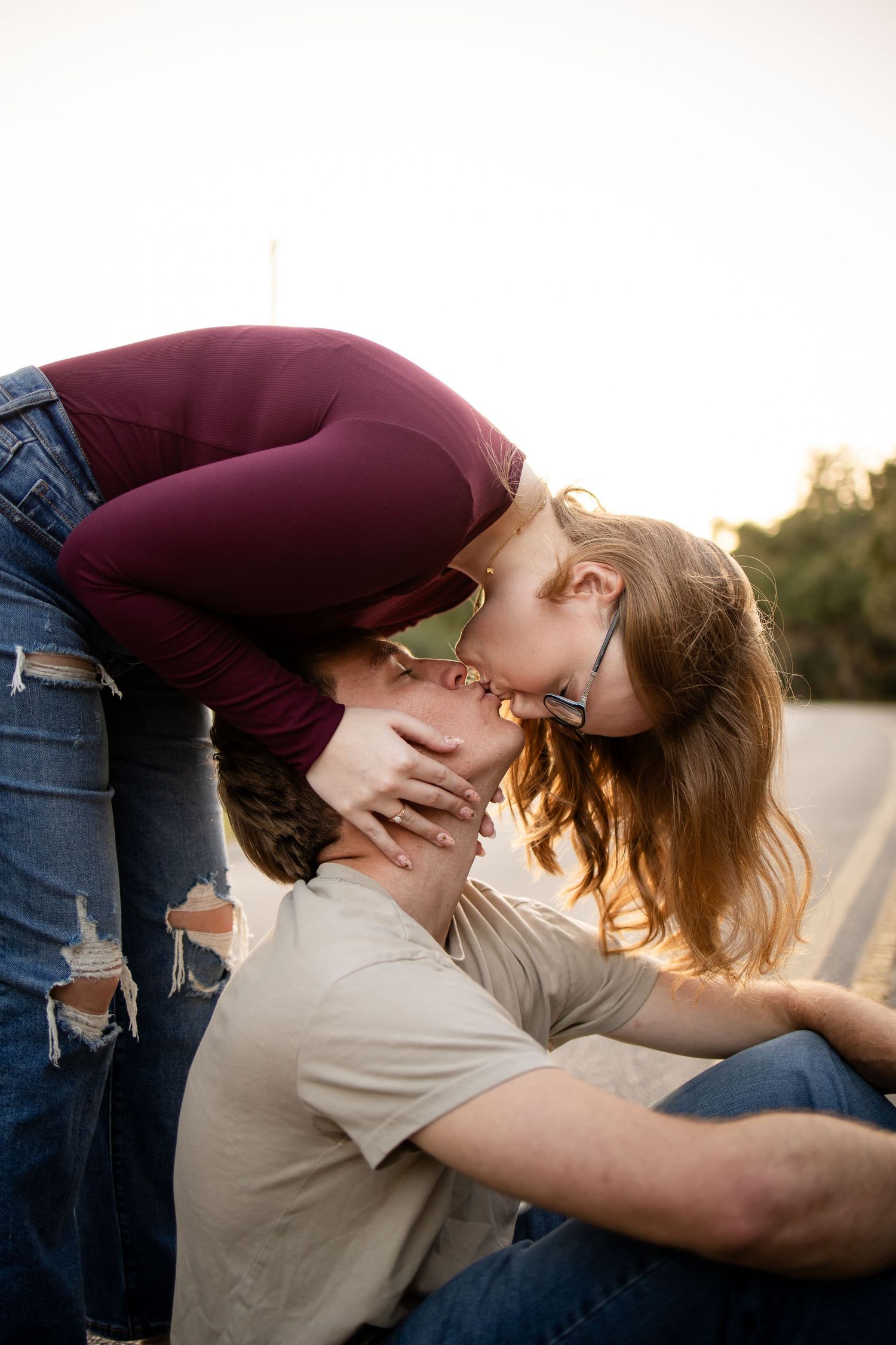 A romantic dip kiss captured during golden hour in an outdoor setting.