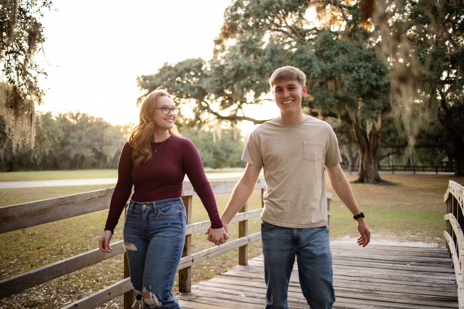 Couple strolling together on a wooden boardwalk during golden hour.