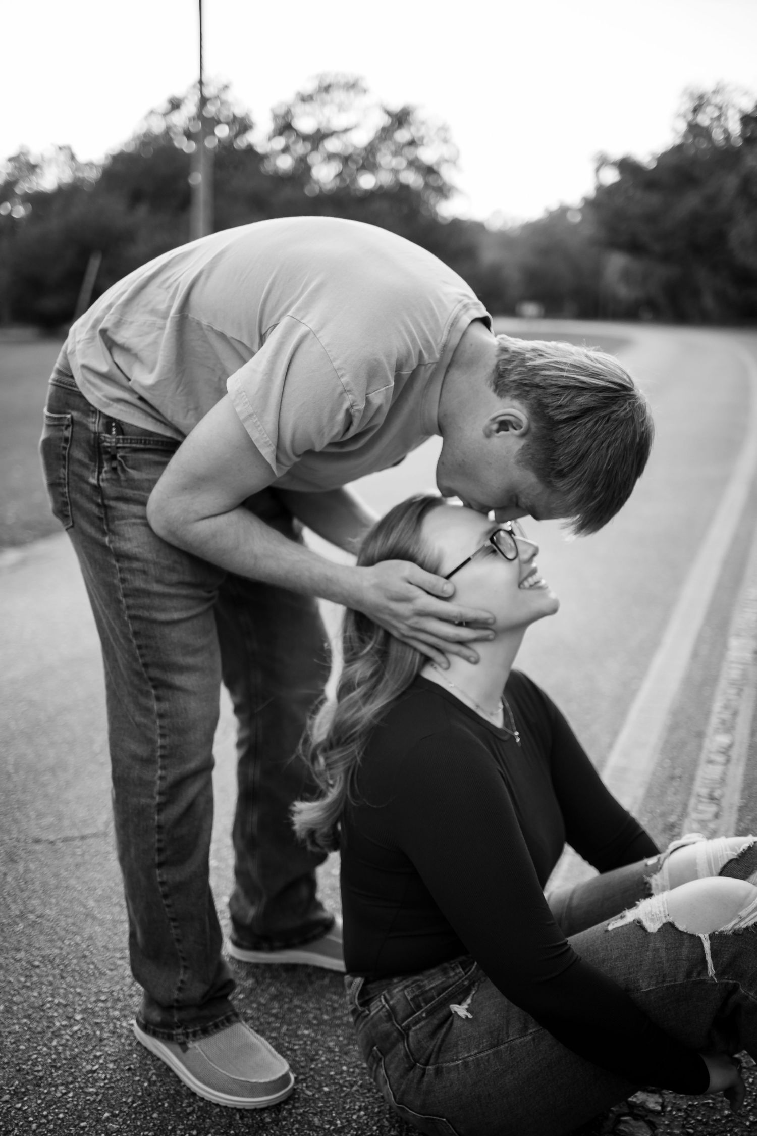 A tender black and white moment captured between a couple on a road.
